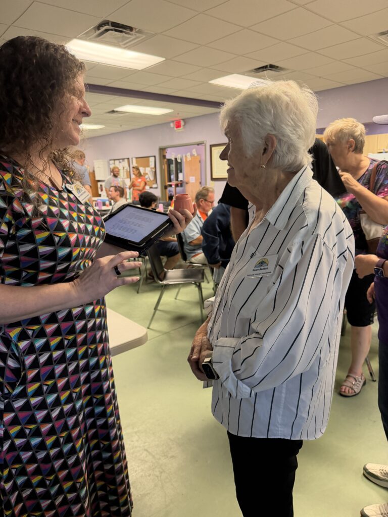 Two members in conversation in the fellowship hall.